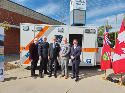 A group standing in front of a Region of Durham Paramedic Services ambulance. From left to right: John Henry, Regional Chair and CEO of Durham Region; Troy Cheseboro, Chief of Region of Durham Paramedic Services; Peter Bethlenfalvy, MPP for Pickering-Uxbridge; Kevin Ashe, Mayor of the City of Pickering; Todd McCarthy, MPP for Durham.