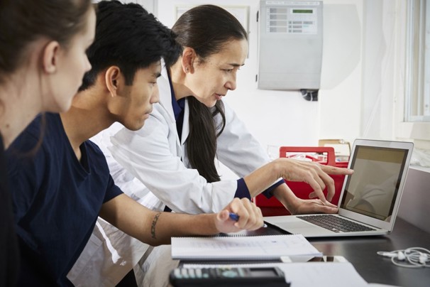People reviewing information on a laptop together