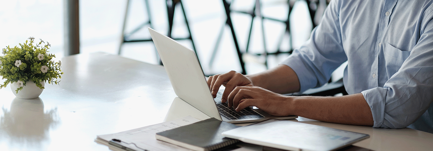 Individual sitting at a desk with a computer