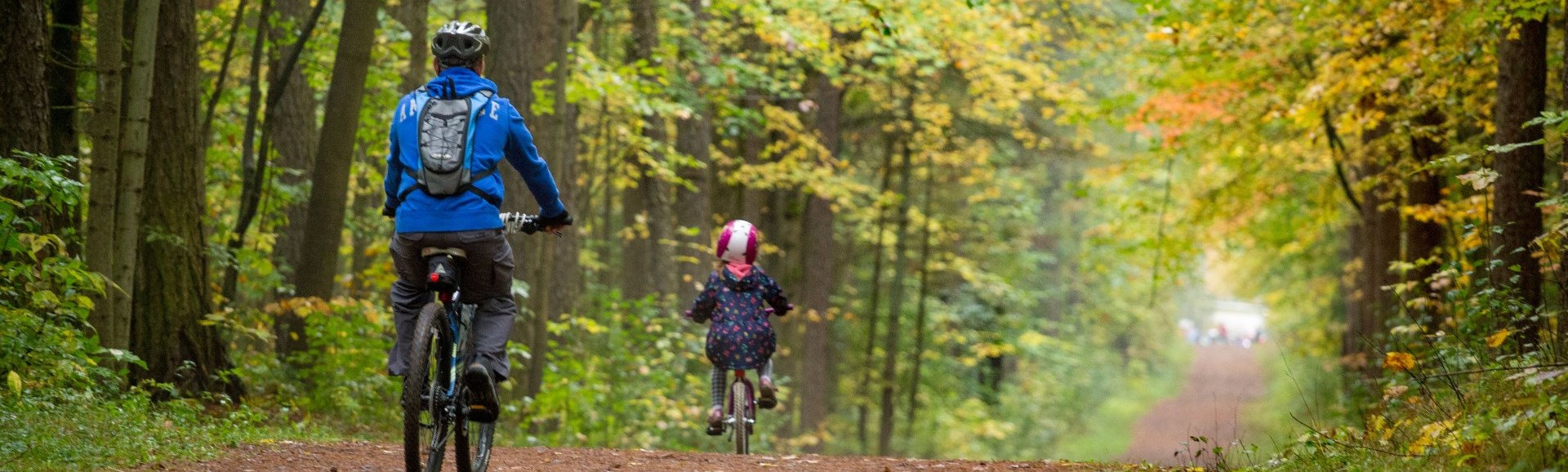 Adult and child mountain biking Adult and child mountain biking on trail