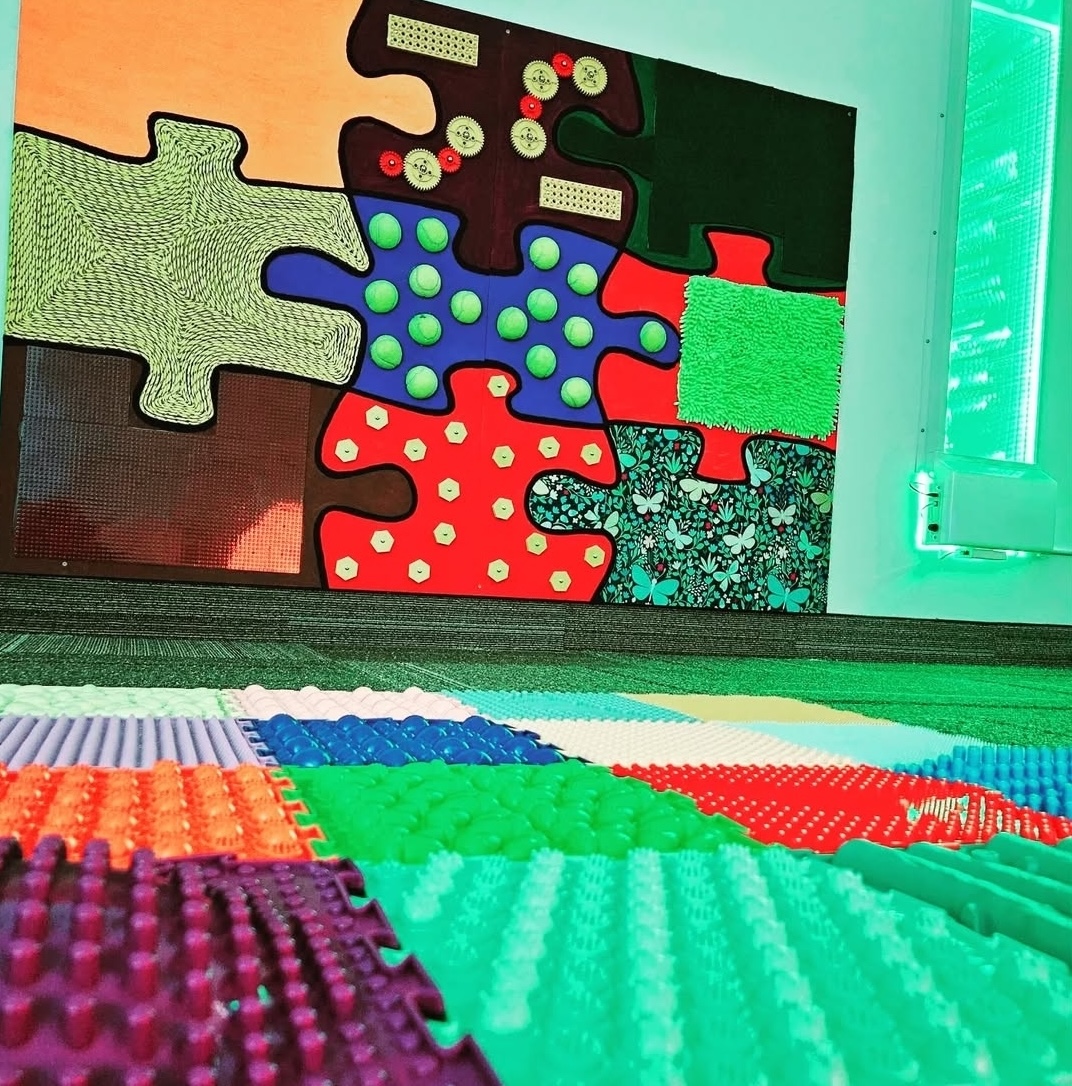 Colourful, sensory, giant puzzle piece wall.