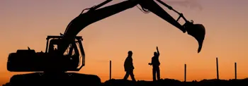 Two-workers-with-machinery-at-sunset.jpg