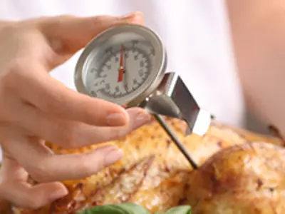 Using a food thermometer to check turkey temperature