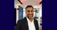 A head shot of Riaz with a blurred background.