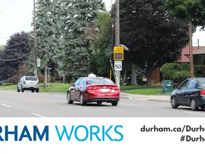 Image shows vehicles driving on road and passing a speed radar feedback sign. Text under image states: “Durham Works, durham.ca/DurhamWorks #DurhamWorks.”