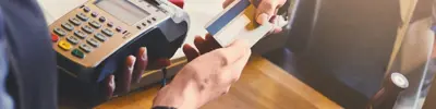 Person paying with a debit card at store terminal