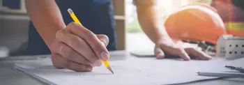 Architect-drawing-plans-on-table.jpg