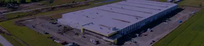 Aerial view of a large warehouse building with loading docks and surrounding parking area.