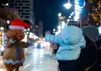 Child waving at a person in a gingerbread man costume at the Santa parade in downtown Oshawa, Ontario