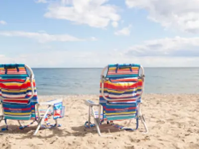 two beach chairs by the water