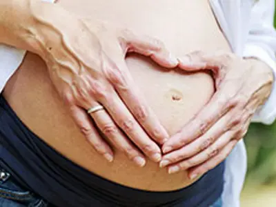 Woman with hands on pregnant belly