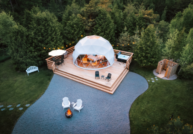 a geodesic camping dome surrounded by trees