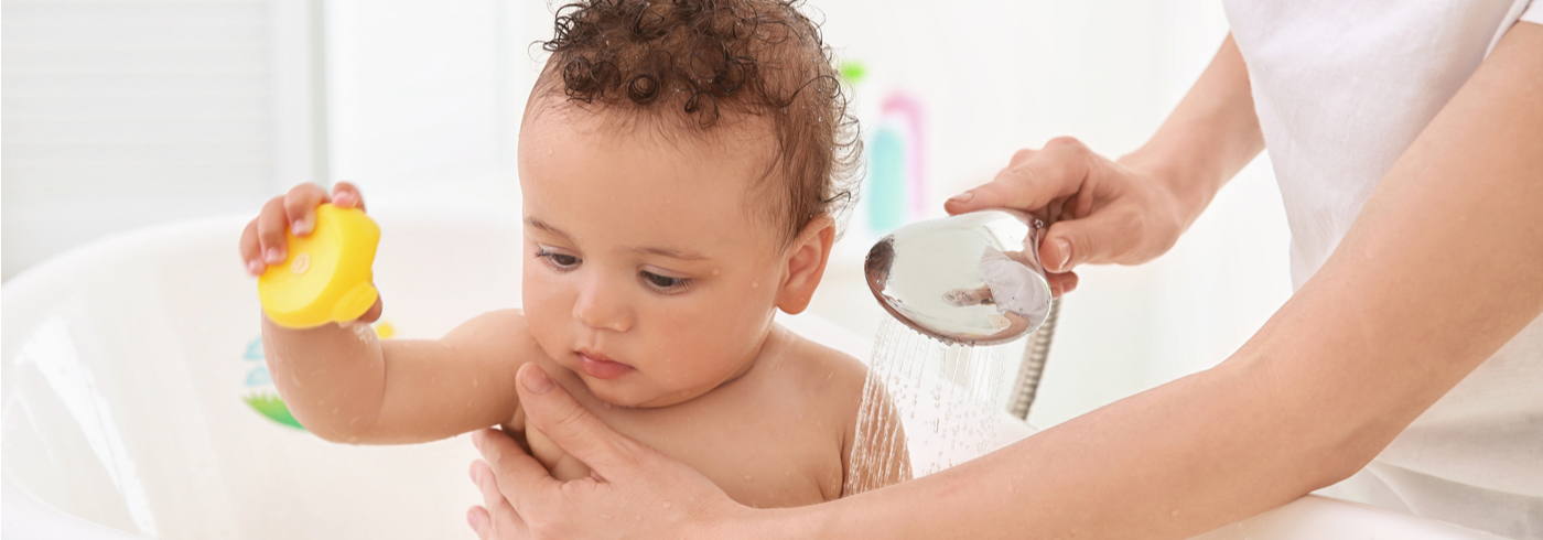 Baby being bathed by parent
